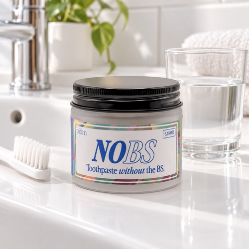 Illustrative bathroom scene with biöm NOBS 62 toothpaste tablets jar, toothbrush and glass of water