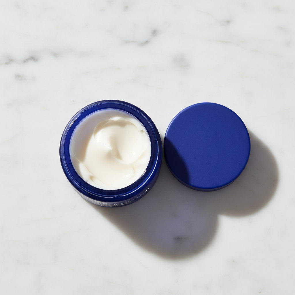 Ursa Major Golden Hour Recovery Cream blue jar open showing cream texture on white marble