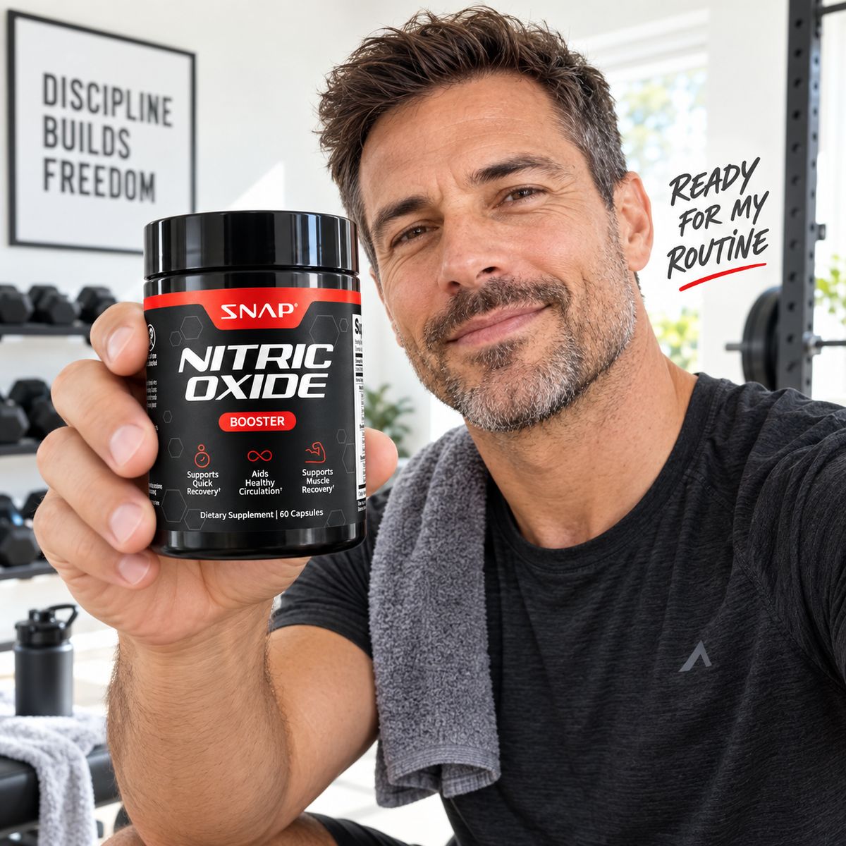 Man holding SNAP Nitric Oxide Booster in a home gym